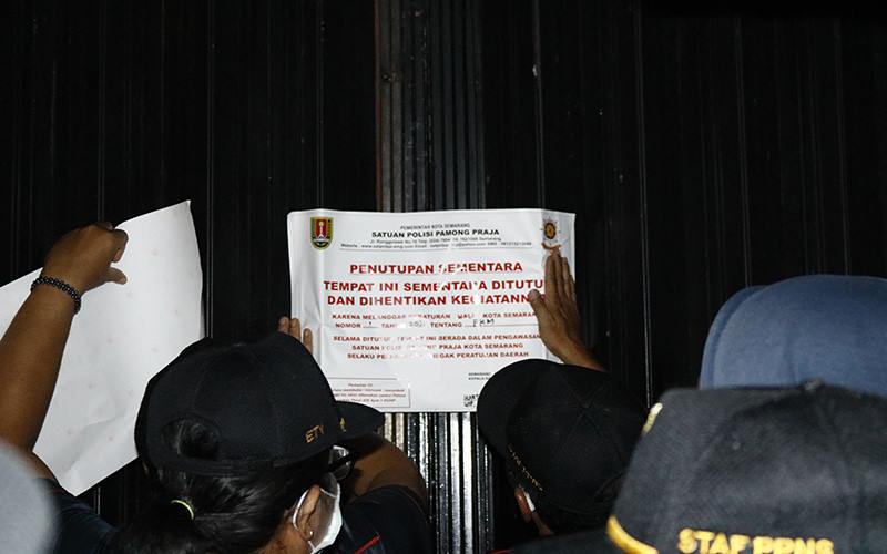 Petugas Satpol PP Kota Semarang menutup tempat usaha yang melanggar ketentuan PPKM, Rabu (13/1/2021). JIBI/Bisnis- Muhammad Faisal Nur Ikhsan 