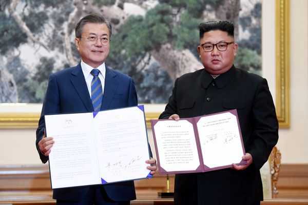 Presiden Korea Selatan Moon Jae-in dan pemimpin tertinggi Korea Utara Kim Jong Un menunjukkan pernyataan bersama kedua negara di Pyongyang, Korea Utara, Rabu (19/9)./Pyeongyang Press Corps via Reuters