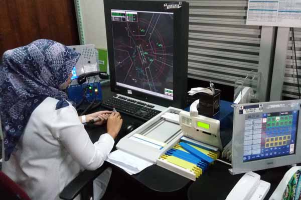Caption: Seorang pegawai AirNav sedang mengamati pergerakan pesawat di Air Traffic Controller Working Positions Bandara Supandio Pontianak/Bisnis.com-Rio Sandy Pradana.