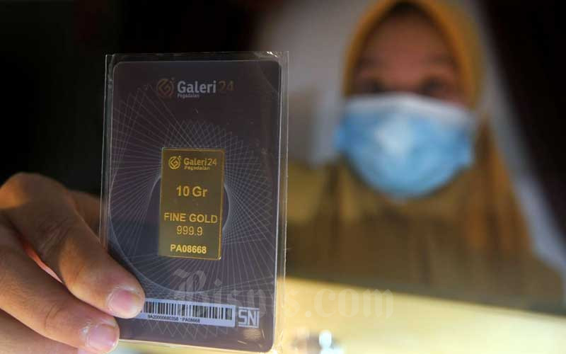 Karyawati menunjukkan emas batang di Galeri 24 Pegadaian di Jakarta, Senin (1/2/2021). Bisnis/Abdurachman