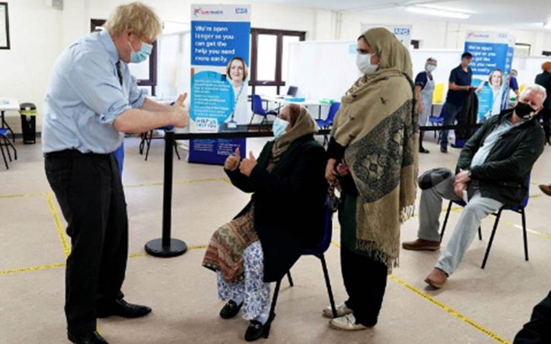 Perdana Menteri Inggris Boris Johnson mengacungkan jempol kepada pasien setelah mereka diberi vaksin saat ia mengunjungi pusat vaksinasi Covid-19 di Batley, West Yorkshire, Inggris, Senin (1/2/2021)./Antara/Reuters/Pool-Jon Super