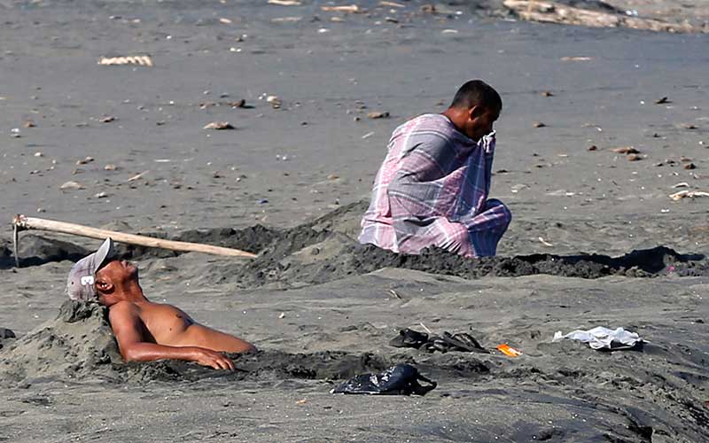  Warga Aceh Melakukan Terapi Pasir Hitam di Pantai Syiah Kuala