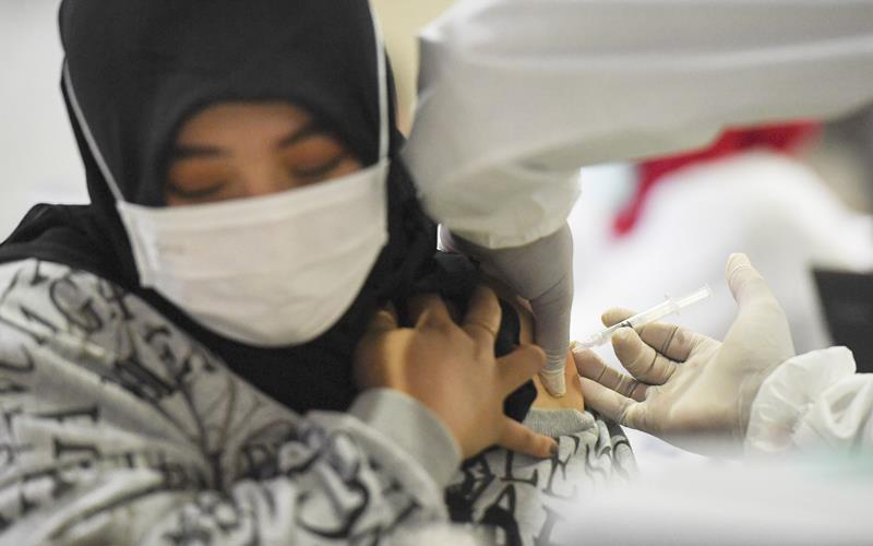 Petugas menyuntikan vaksin Covid-19 kepada pedagang di Pasar Tanah Abang Blok A, Jakarta, Rabu (17/2/2021). Vaksinasi Covid-19 tahap kedua yang diberikan untuk pekerja publik dan lansia itu dimulai dari pedagang Pasar Tanah Abang. ANTARA FOTO/Hafidz Mubarak A