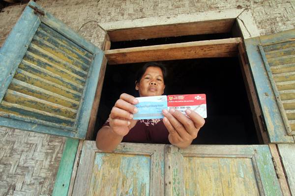 Warga menunjukan kartu peserta Program Keluarga Harapan (PKH) di Desa Gunung Sari, Citeureup, Bogor, Jawa Barat, Jumat (14/12/2018)./ANTARA-Yulius Satria Wijaya