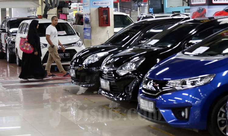 Pengunjung melintasi deretan mobil bekas yang dijual di Jakarta, Selasa (3/3/2020). Bisnis/Eusebio Chrysnamurti