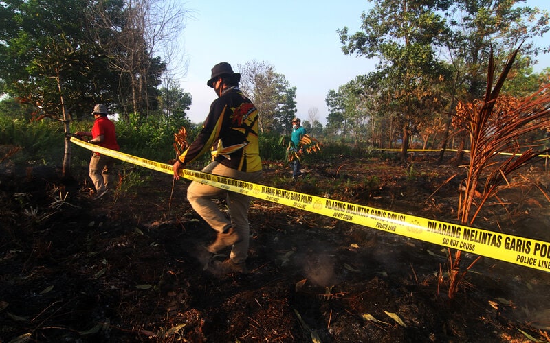 Petugas Dit Reskrimsus Polda Kalbar menyegel lahan gambut yang dibakar pemiliknya di Jalan Perdana, Gang Wak Sidik jalur 9 Kelurahan Bansir Darat, Pontianak, Kalimantan Barat, Sabtu (27/2/2021). Tim Unit 2 Subdit 4 Ditreskrimsus Polda Kalbar menyegel lahan berukuran 10 x 20 meter yang sengaja dibakar untuk membuka lahan bercocok tanam oleh pemiliknya bernama Samsul Bahri pada Senin (22/2) hingga mengakibatkan api merambat ke lahan milik warga di sekitarnya seluas lima hektar./Antara-Jessica Helena Wuys.