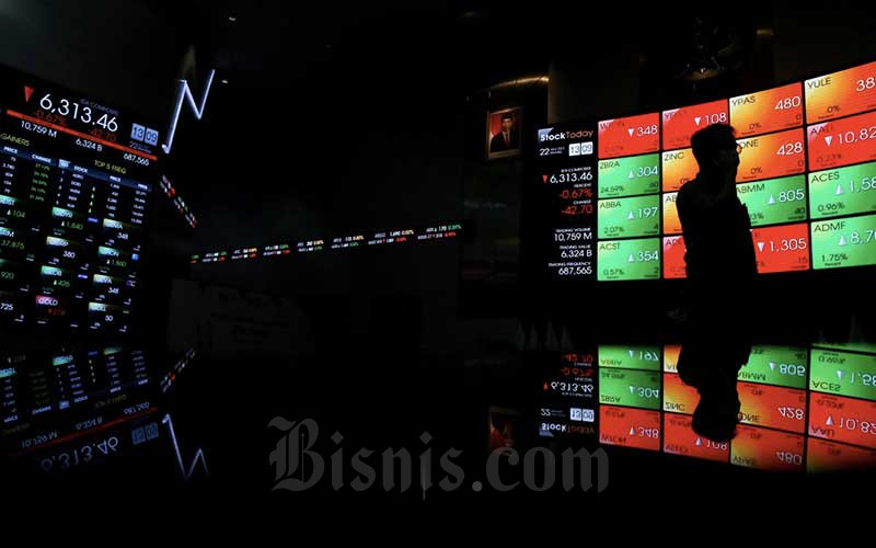 Pengunjung melintasi papan elektronik yang menampilkan pergerakan indeks harga saham gabungan (IHSG) di Bursa Efek Indonesia, Jakarta, Senin (22/3/2021). Bisnis/Eusebio Chrysnamurti