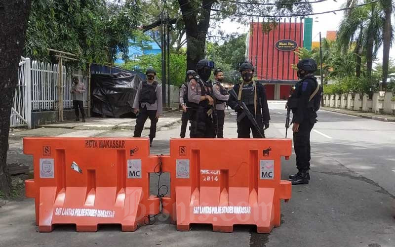 Petugas kepolisian berjaga di lokasi dugaan bom bunuh diri di depan Gereja Katedral Makassar, Sulawesi Selatan, Minggu (28/3/2021). Bisnis/Paulus Tandi Bone 