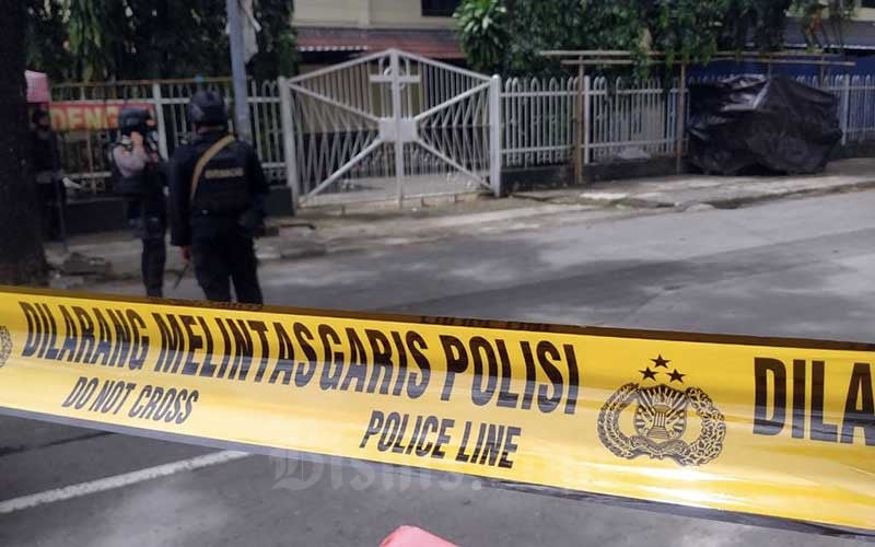 Petugas kepolisian berjaga di lokasi dugaan bom bunuh diri di depan Gereja Katedral Makassar, Sulawesi Selatan, Minggu (28/3/2021). Bisnis/Paulus Tandi Bone 