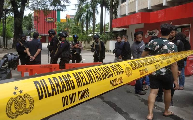 Polisi menutup akses jalan sekitar Gereja Katedral Makassar setelah terjadi ledakan, Minggu (28/3/2021)./Bisnis-Paulus Tandi Bone
