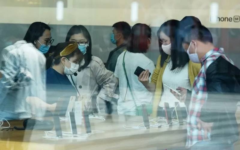 Warga memakai masker pelindung menyusul penyebaran penyakit  Covid-19 di Apple Store saat penjualan iPhone SE baru dimulai, di Hangzhou, Provinsi Zhejiang, China, Jumat (24/4/2020)./Antara