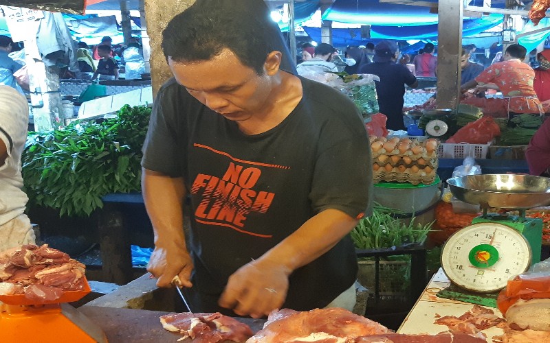 Pegadang memotong daging sapi untuk pembeli /Bisnis-Arif gunawan