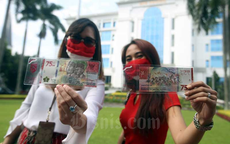 Warga memperlihatkan uang lembar pecahan Rp75.000 usai melakukan penukaran di Kantor Perwakilan wilayah Bank Indonesia (KPw BI) Jawa Barat, Bandung, Jawa Barat, Selasa (18/8/2020). Bisnis/Rachman