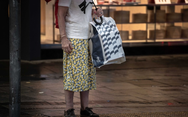 Warga Hong Kong membawa tas belanja dari sebuah department store ternama di Hong Kong, China, Sabtu (30/5/2020)./Bloomberg-Ivan Abreu