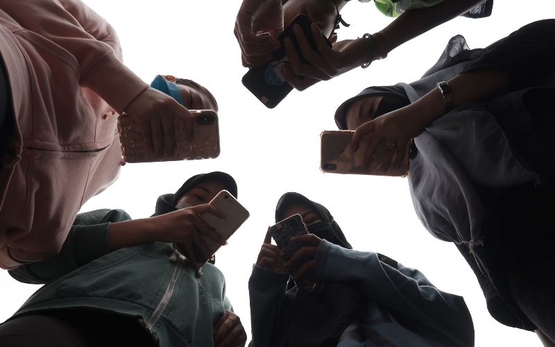 Sejumlah remaja menggunakan ponsel saat berkomunikasi di Medan, Sumatera Utara, Jumat (17/4/2020)./ANTARA FOTO-Septianda Perdana