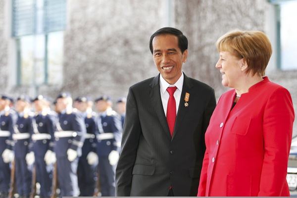 Presiden Joko Widodo (kiri) berbincang dengan Kanselir Jerman Angela Merkel saat upacara penyambutan kedatangan Jokowi di Berlin, Jerman, Senin (18/4)./REUTERS-Hannibal Hanschke