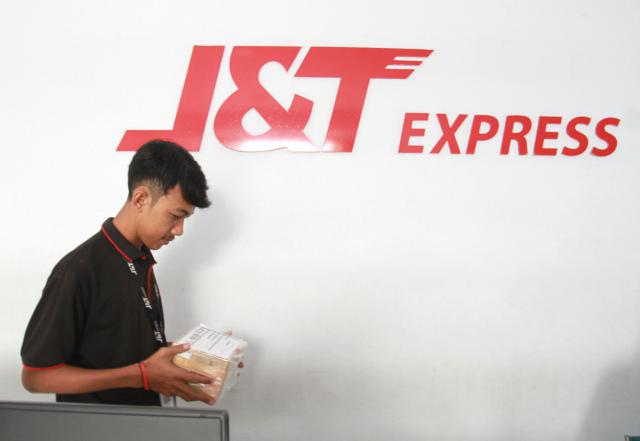 Ilustrasi - Karyawan pengiriman barang J&T memindahkan barang kiriman./Bisnis-Paulus  Tandi Bone