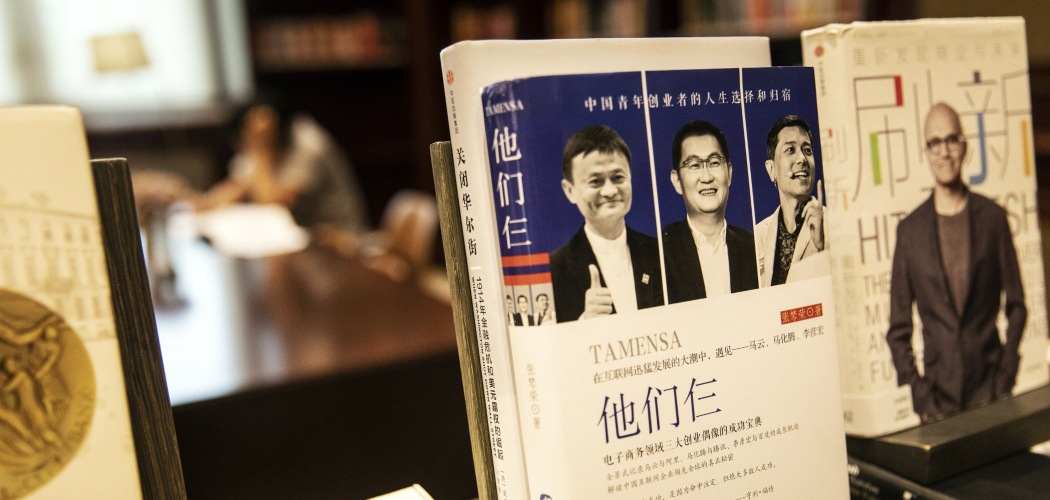 Foto eks Chairman Alibaba Group Holding Ltd. Jack Ma (kiri) dan Chairman serta CEO Tencent Holdings Ltd. Ma Huateng (tengah), bersama co-Founder dan CEO Baidu Inc. Robin Li (kanan), terpampang di sampul sebuah buku di perpustakaan milik Huawei Technologies Co. di kantor pusat perusahaan tersebut di Shenzen, China, Rabu (22/5/2019)./Bloomberg-Qilai Shen