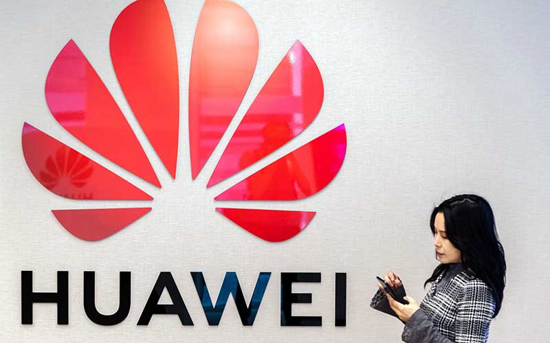 Warga menggunakan smartphone di dekat logo Huawei Technologies Co. di Brussels, Belgia. /Bloomberg-Geert Vanden Wijngaert