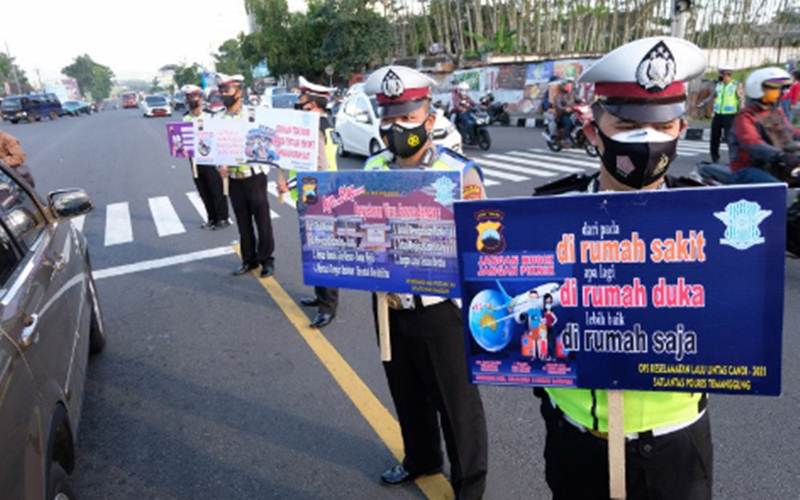 Ilustrasi - Polisi membawa poster saat kampanye larangan mudik di kawasan Terminal Madureso, Temanggung, Jateng, Rabu (21/4/2021)./Antara-Anis Efizudin