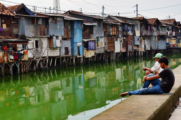 Warga memancing di Sungai Grogol yang bantarannya dipenuhi rumah kumuh di Jalan Tanjung Selor, Grogol, Jakarta Barat, Jumat (24/3)./Antara-Atika Fauziyyah