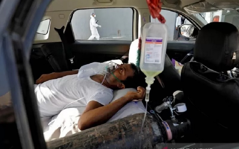 Seorang pasien dengan gangguan pernapasan berbaring di dalam mobil sambil menunggu untuk masuk rumah sakit Covid-19 untuk perawatan, di tengah penyebaran Covid-19 di Ahmedabad, India, Kamis (22/4/2021)./Antara-Reutersrnrn