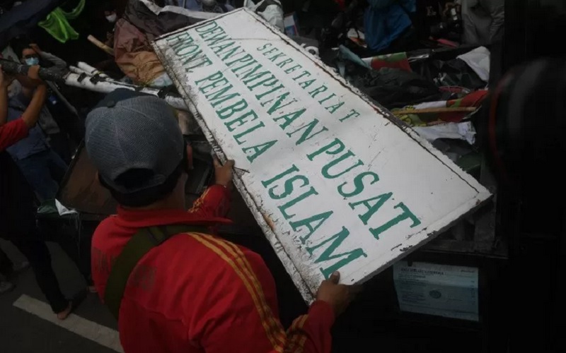 Petugas membongkar atribut saat melakukan penutupan markas DPP Front Pembela Islam (FPI) di Petamburan, Jakarta, Rabu (30/12/2020). /Antararn