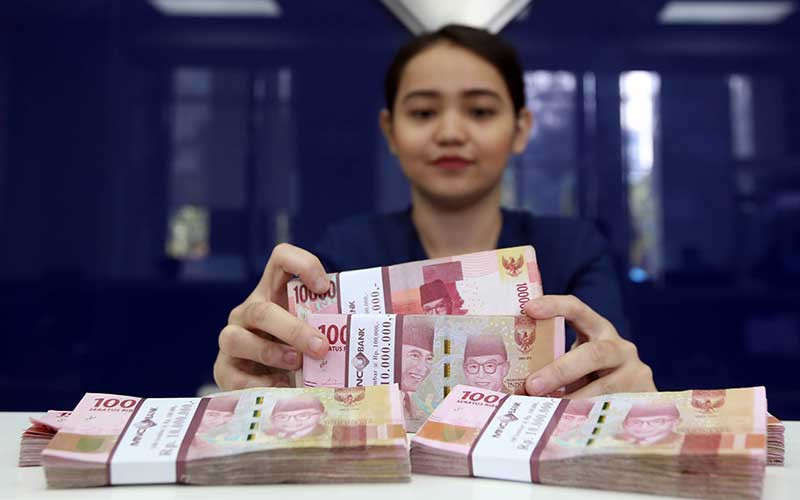 Karyawan menghitung uang pecahan Rp.100.000 di salah satu Bank yang ada di Jakarta, Senin (4/6). Bisnis/Abdullah Azzam