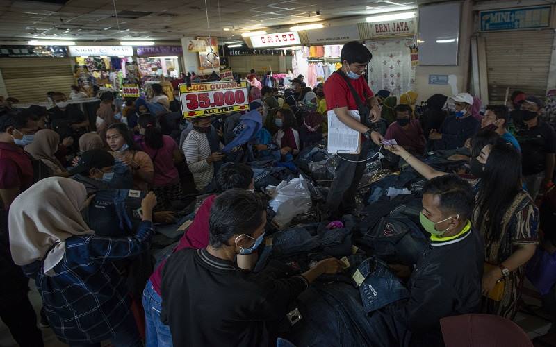 Sejumlah warga berbelanja pakaian di Blok B Pusat Grosir Pasar Tanah Abang, Jakarta Pusat, Minggu (2/5/2021). Gubernur DKI Anies Baswedan mengakui adanya lonjakan pengunjung di pusat tekstil terbesar se-Asia Tenggara tersebut, dari sekitar 35.000 pengunjung pada hari biasa menjadi sekitar 87.000 orang pada akhir pekan ini sehingga pihaknya menyiagakan sekitar 750 petugas untuk menjaga kedisiplinan protokol kesehatan untuk mencegah penularan Covid-19. ANTARA FOTO/Aditya Pradana Putra/foc.rn