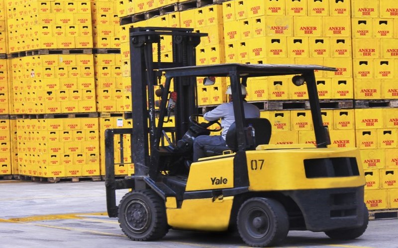 Petugas mengoperasikan forklift untuk memindahkan kerat-kerat berisi botol bir.//deltajkt.co.id