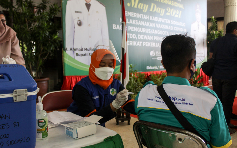 Petugas kesehatan menyuntikkan vaksin Covid-19 Astrazeneca kepada buruh di Pendopo Sidoarjo, Jawa Timur, Sabtu (1/5/2021). Sebanyak 500 buruh dari berbagai element tersebut menerima vaksinasi Covid-19 dalam rangka peringatan Hari Buruh Sedunia. /ANTARA FOTO