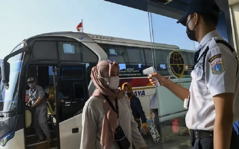 Petugas memeriksa suhu tubuh dari pemudik saat tiba di Terminal Terpadu Pulo Gebang, Jakarta Timur, Sabtu (15/5/2021)./Antara