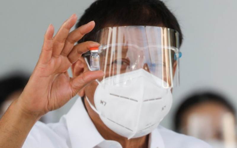 Presiden Filipina Rodrigo Duterte saat memegang sebotol vaksin virus corona (COVID-19) Sinovac, vaksin COVID-19 pertama yang tiba di negara itu, di Pangkalan Udara Villamor, Kota Pasay, Metro Manila, Filipina, Minggu (28/2/2021)./Antara/Reuters-Eloisa Lopez