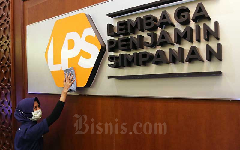 Karyawan membersihkan logo Lembaga Penjamin Simpanan (LPS)./Bisnis-Eusebio Chrysnamurti