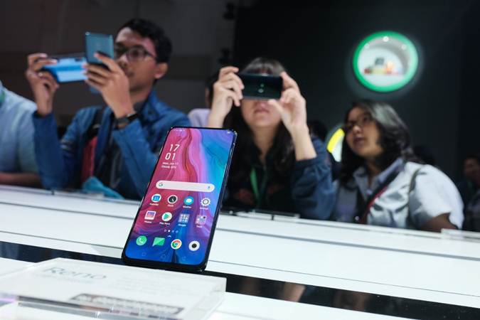 Pengunjung mencoba produk terbaru Oppo Reno di sela-sela peluncurannya di Jakarta, Senin (17/6/2019)./Bisnis-Felix Jody Kinarwan