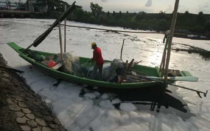 Nelayan beraktivitas di muara Sungai Tambak Wedi yang permukaannya penuh busa putih di Surabaya, Jawa Timur, Minggu (29/3/2020)./Antara