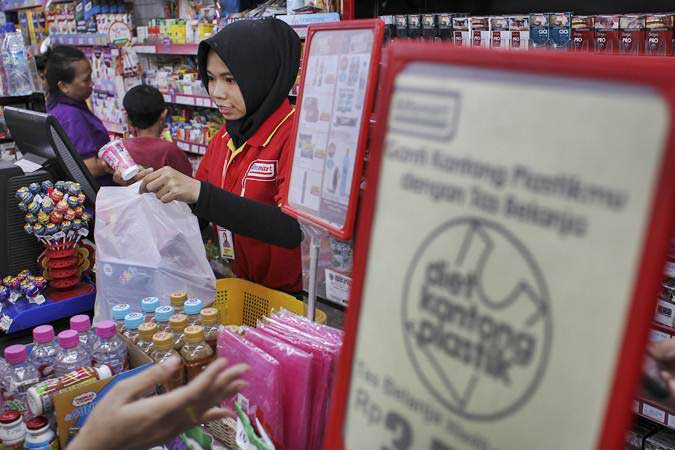Pramuniaga memasukkan barang yang telah dibeli konsumen ke dalam kantong plastik di salah satu mini market di kawasan Jakarta Timur, Jumat (1/3/2019)./ANTARA-Dhemas Reviyanto