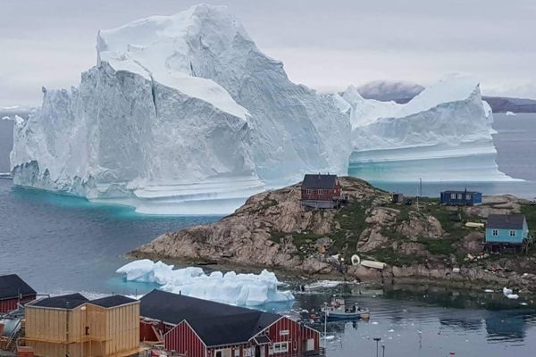 Sebuah gunung es raksasa terlihat di dekat Desa Innaarsuit, Greenland, Kamis (12/7)./Magnus Kristensen via Reuters
