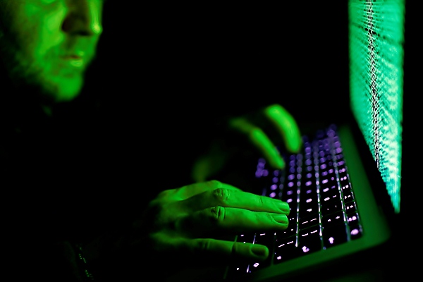 Ilustrasi seorang pria sedang mengetik kode siber./Reuters-Kacper Pempe