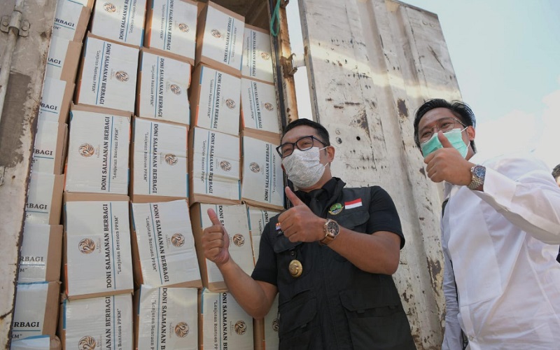 Gubernur Jawa Barat Ridwan Kamil (kiri) bersama Doni Salmanan (kanan) saat pembagian paket sembako di Kota Baru Parahyangan, Padalarang, Kabupaten Bandung Barat