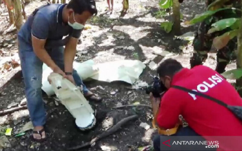 Petugas memeriksa temuan benda diduga serpihan pesawat di Desa Dawu, Kecamatan Paron, Kabupaten Ngawi, Jawa Timur, Selasa (10/8/2021)./Antara-Louis Rika