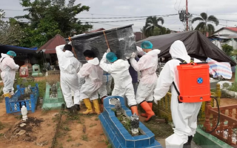 Tim KBR Brimob Polda Kalimantan Selatan membantu memakamkan jenazah pasien Covid-19./Antara