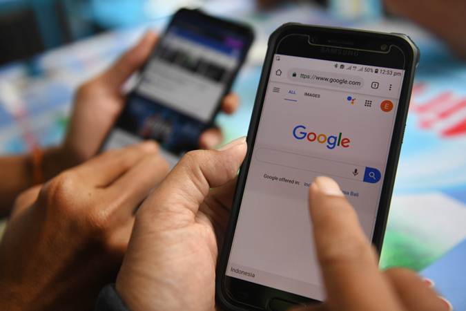 Dua orang membuka laman Google dan aplikasi Facebook melalui gawainya di Jakarta, Jumat (12/4/2019)./ANTARA-Akbar Nugroho Gumay