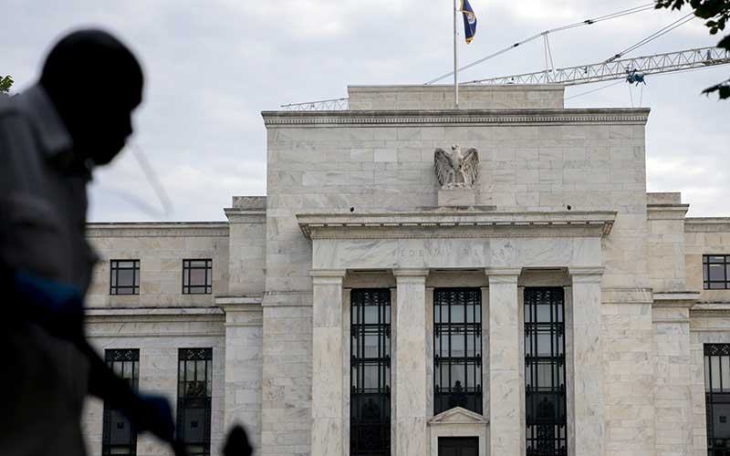 Warga melintas di depan gedung bank central Amerika Serikat atau The Federal Reserve di Washington, Amerika Serikat, Rabu (31/7/2019). Bloomberg/Andrew Harrer