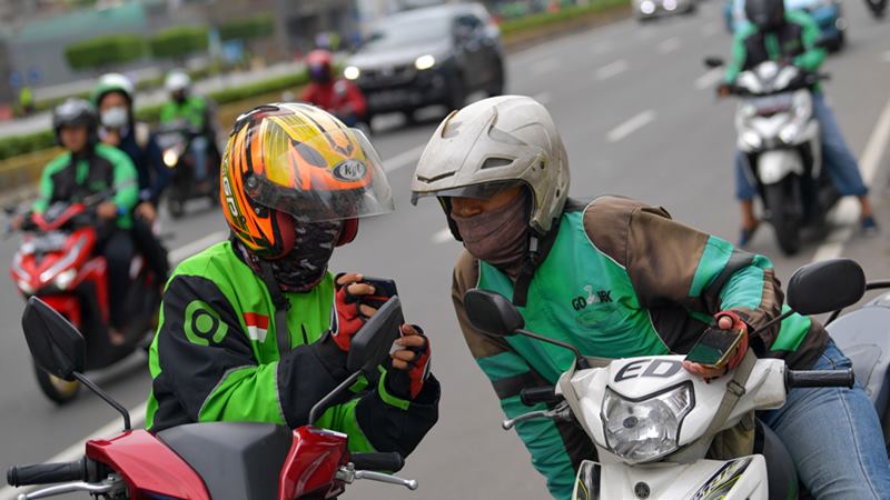 Dua orang pengemudi ojek online berbincang di Jalan Thamrin, Jakarta, Senin (17/2/2020)./ANTARA - M Risyal Hidayatn