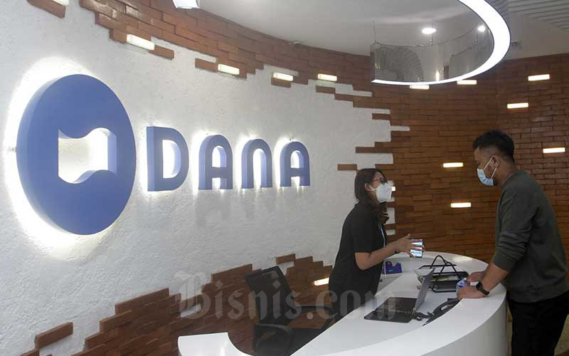Karyawati beraktivitas di dekat logo Dana di Jakarta, Jumat (16/4/2021). Bisnis/Himawan L Nugraha