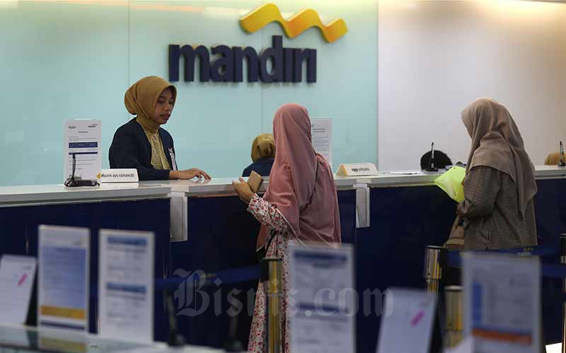 Karyawan melayani nasabah di salah satu kantor cabang milik PT Bank Mandiri (Persero) Tbk. di Jakarta, Kamis (4/7). Bisnis/Nurul Hidayat