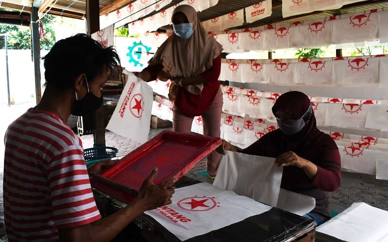 Pekerja membuat tas berbahan kain di tempat Usaha Mikro Kecil Menengah (UMKM) di Kota Madiun, Jawa Timur, Sabtu (31/7/2021). /Antara Foto-Siswowidodo