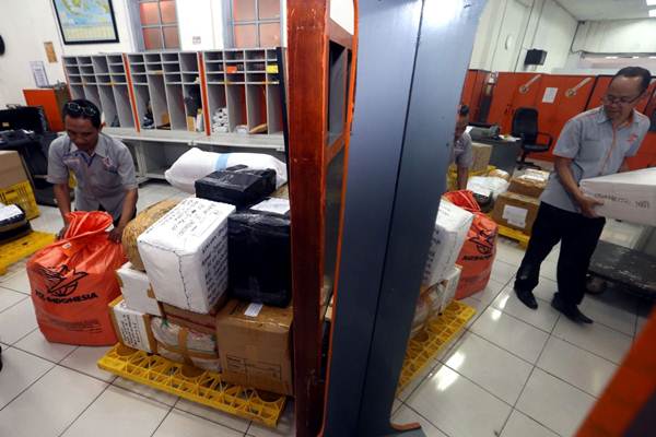 Pekerja mendata paket barang sebelum dialihkan ke pusat pemrosesan pos untuk dikirim ke tujuan, di Kantor Pos Besar Bandung, Jawa Barat, Rabu (6/6/2018)./JIBI-Rachman