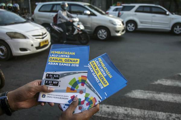 Petugas Badan Pengelola Transportasi Jabodetabek (BPTJ) melakukan sosialisasi kepada pengguna kendaraan bermotor pada hari pertama uji coba perluasan kawasan ganjil genap di persimpangan Pancoran, Jakarta, Senin (2/7/2018)./ANTAR-Aprillio Akbar